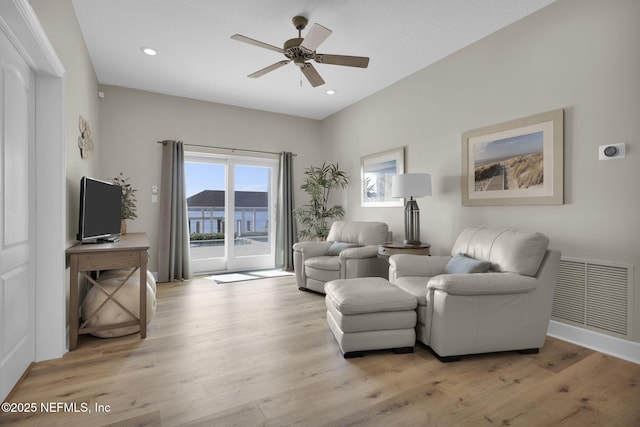 living room with light hardwood / wood-style floors and ceiling fan