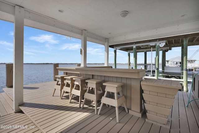 view of dock with a water view and a bar