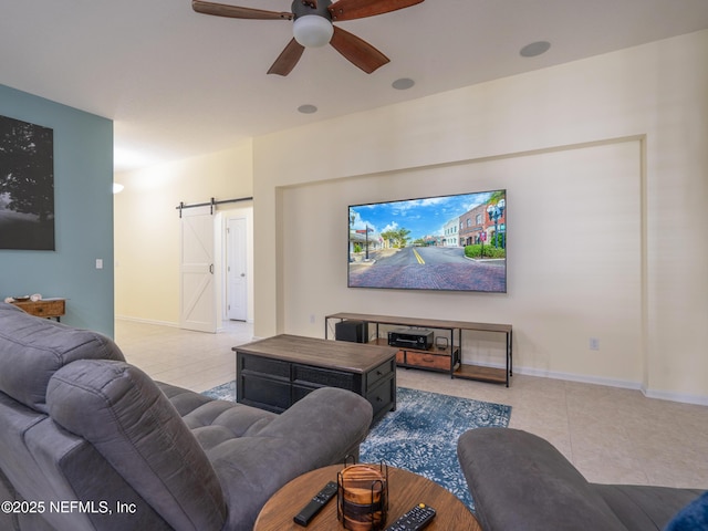 living room with a barn door, light tile patterned floors, and ceiling fan