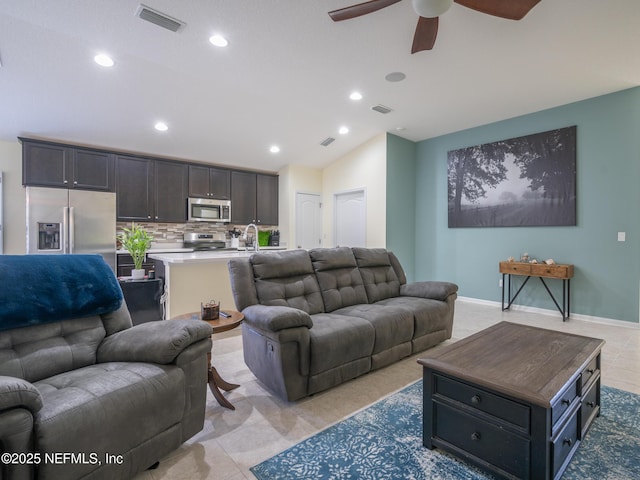 living room featuring lofted ceiling, sink, and ceiling fan