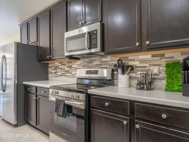 kitchen featuring light tile patterned flooring, appliances with stainless steel finishes, dark brown cabinets, and decorative backsplash