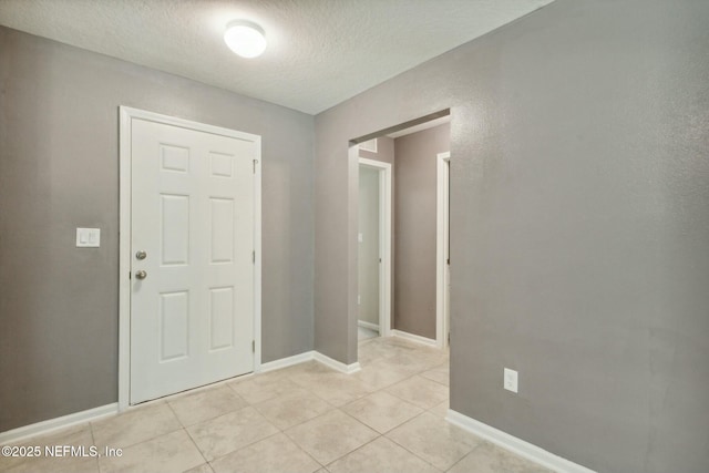 tiled foyer entrance with a textured ceiling