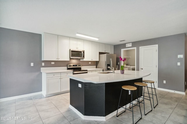 kitchen with sink, a center island with sink, white cabinets, and appliances with stainless steel finishes