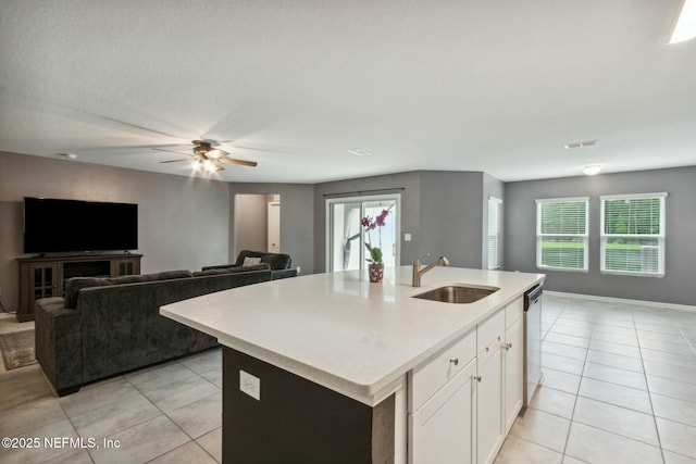 kitchen with white cabinetry, sink, stainless steel dishwasher, and an island with sink