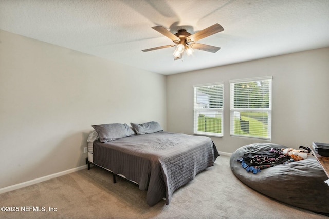 bedroom featuring light carpet, a textured ceiling, and ceiling fan