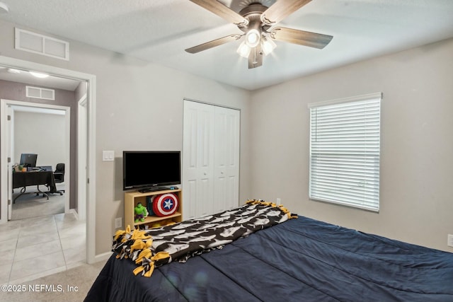 carpeted bedroom with ceiling fan and a closet