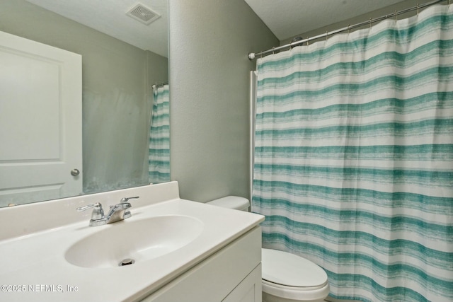 bathroom with a shower with curtain, vanity, and toilet