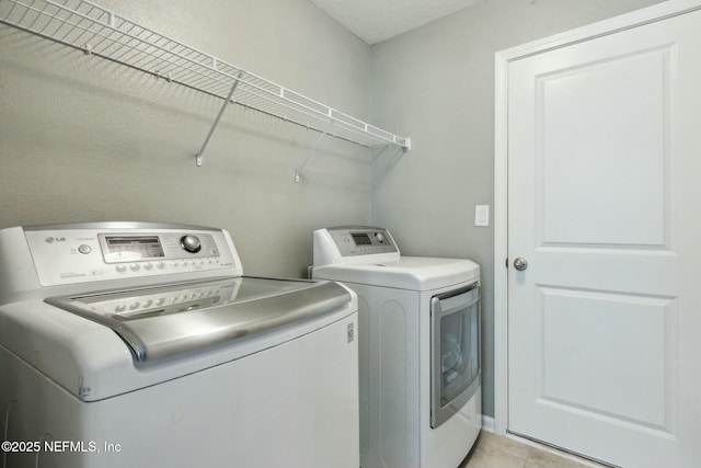 laundry room with light tile patterned flooring and washer and dryer