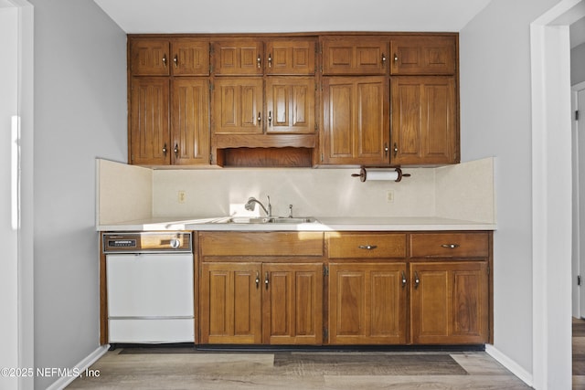 kitchen featuring sink, decorative backsplash, and light wood-type flooring