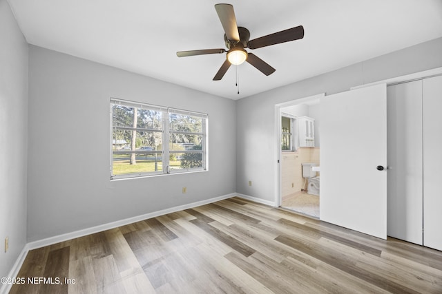 unfurnished bedroom featuring ceiling fan, a closet, connected bathroom, and light hardwood / wood-style flooring