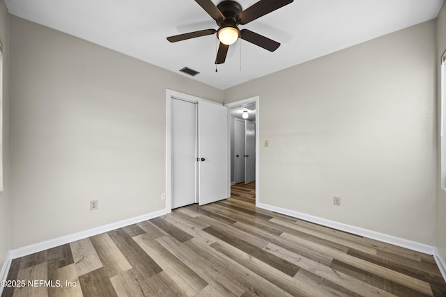 unfurnished bedroom with ceiling fan, light hardwood / wood-style floors, and a closet