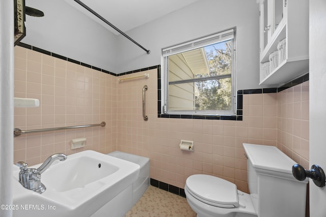 bathroom with tile walls, sink, and toilet