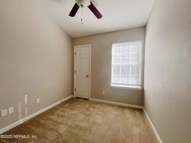 carpeted spare room with ceiling fan, vaulted ceiling, and a textured ceiling