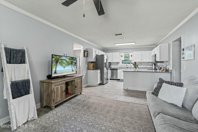 living room featuring crown molding, light hardwood / wood-style flooring, and a textured ceiling