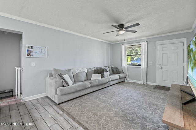 living room featuring crown molding, ceiling fan, and a textured ceiling