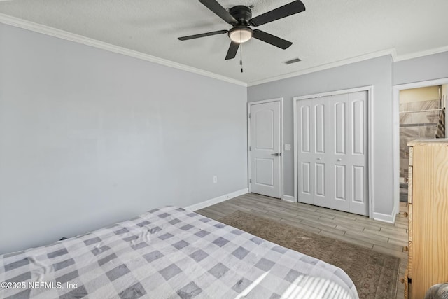 unfurnished bedroom with ornamental molding, a closet, a textured ceiling, and light hardwood / wood-style flooring