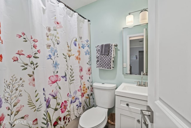 bathroom featuring vanity, a shower with shower curtain, and toilet