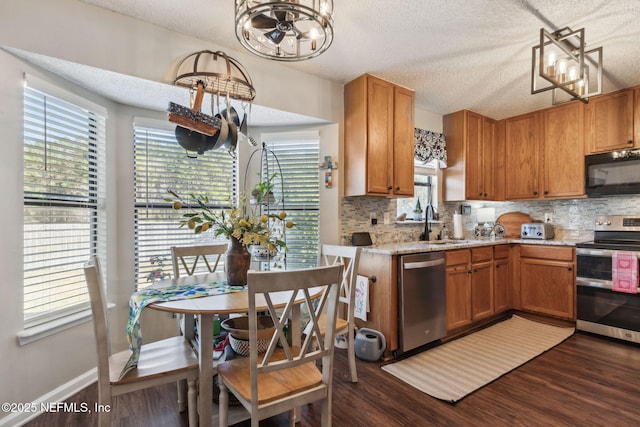 kitchen with sink, a textured ceiling, dark hardwood / wood-style floors, stainless steel appliances, and backsplash