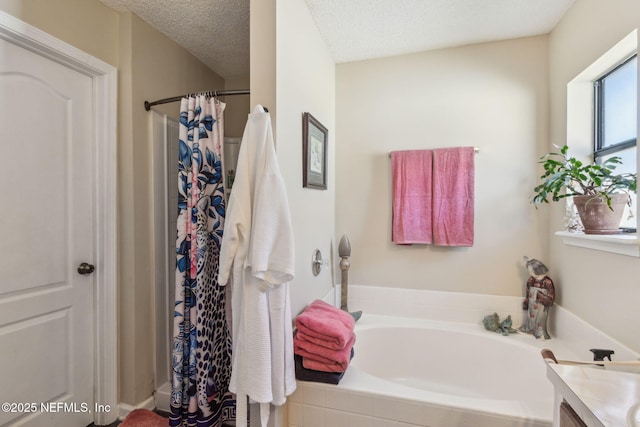 bathroom featuring vanity, plus walk in shower, and a textured ceiling