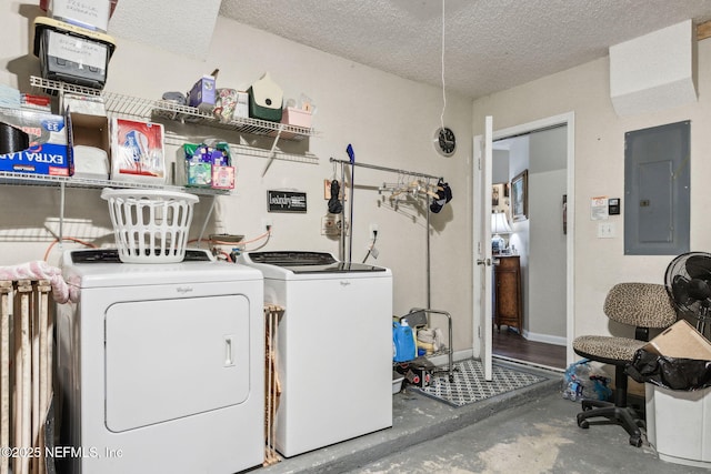 washroom featuring separate washer and dryer, electric panel, and a textured ceiling