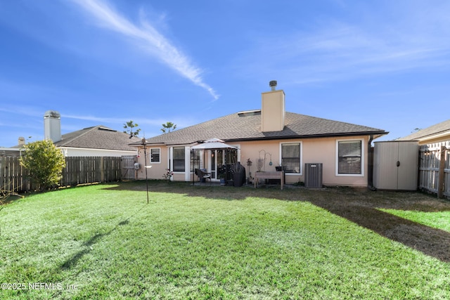 rear view of house with a gazebo, a lawn, and central air condition unit