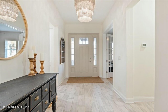 foyer entrance with a chandelier and light wood-type flooring