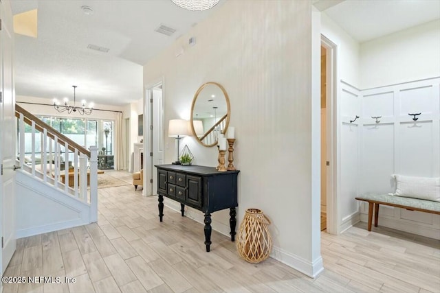 hallway with light hardwood / wood-style flooring and a chandelier