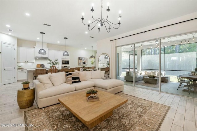 living room with an inviting chandelier and light wood-type flooring