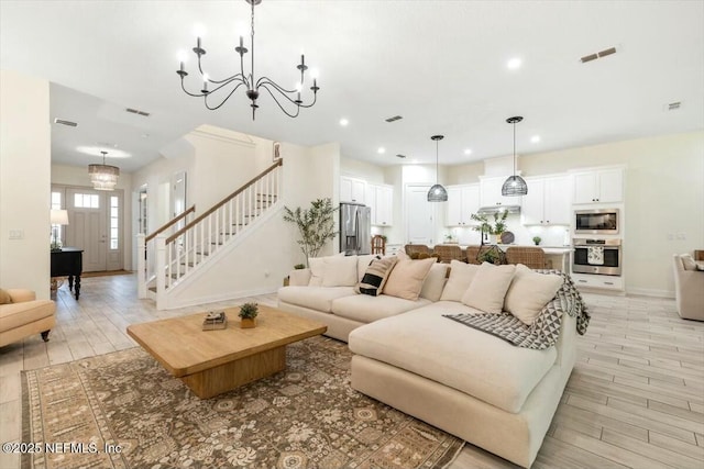 living room featuring a notable chandelier and light wood-type flooring