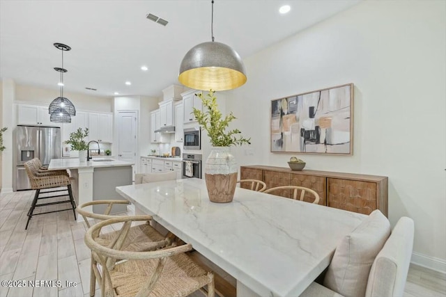 dining space with sink and light hardwood / wood-style flooring