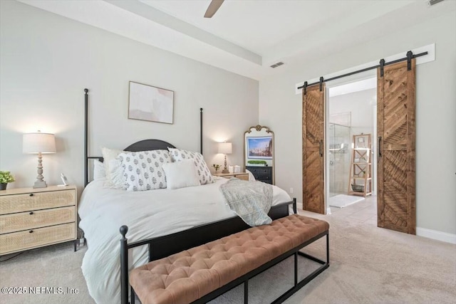 carpeted bedroom with a barn door and ceiling fan