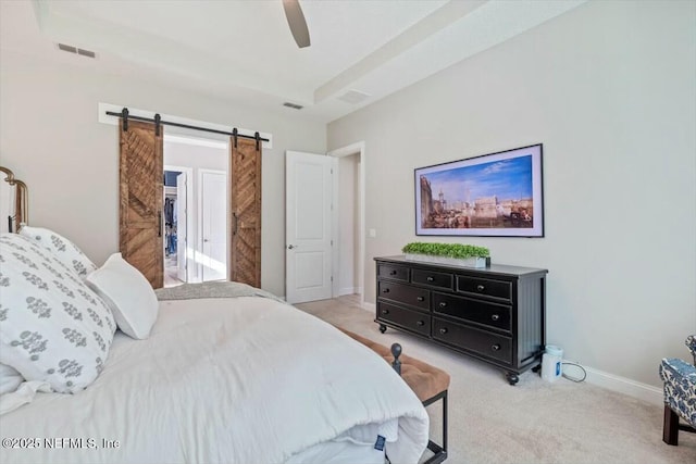 carpeted bedroom featuring ceiling fan and a barn door