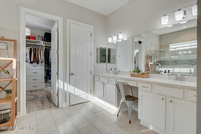 bathroom with tile patterned flooring, vanity, and walk in shower