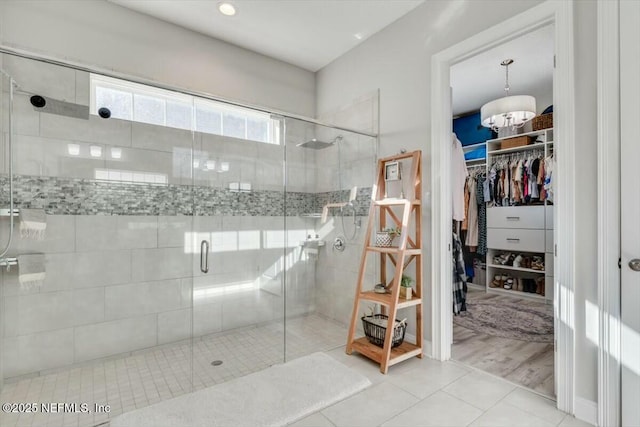 bathroom with walk in shower, tile patterned floors, and a notable chandelier