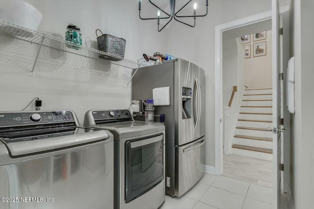 clothes washing area featuring washing machine and dryer and light tile patterned floors