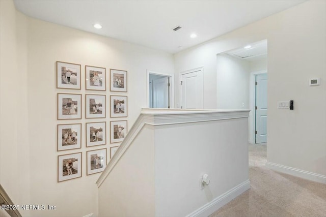 hallway featuring light colored carpet