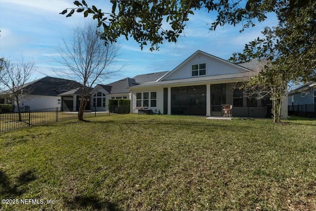 rear view of house featuring a yard and a sunroom