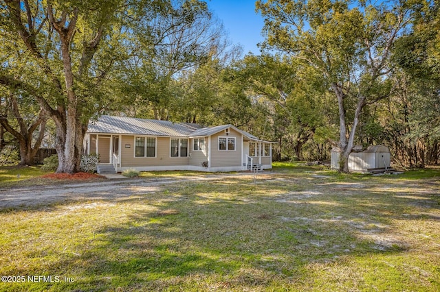 view of front of home featuring a front lawn and a shed