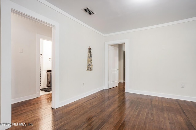 spare room featuring dark wood-type flooring and ornamental molding