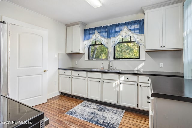 kitchen featuring white cabinetry, sink, and light hardwood / wood-style flooring