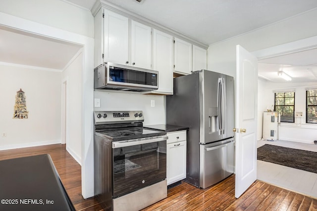 kitchen with white cabinetry, dark hardwood / wood-style flooring, ornamental molding, stainless steel appliances, and electric water heater