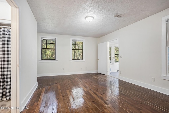 unfurnished room with dark hardwood / wood-style floors and a textured ceiling