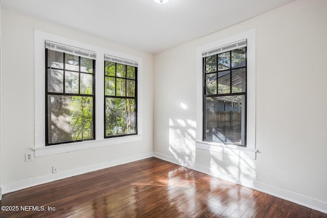 unfurnished room with dark hardwood / wood-style flooring