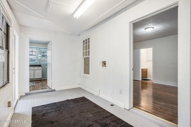 spare room featuring wood-type flooring and a textured ceiling