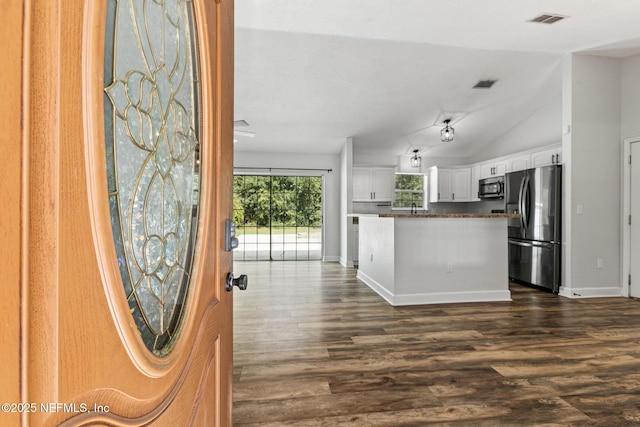 kitchen featuring lofted ceiling, sink, stainless steel refrigerator, white cabinets, and dark hardwood / wood-style flooring