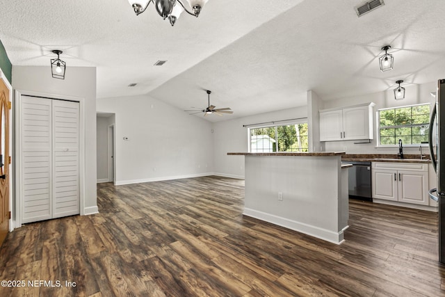 kitchen featuring dark hardwood / wood-style flooring, a wealth of natural light, stainless steel dishwasher, and white cabinets