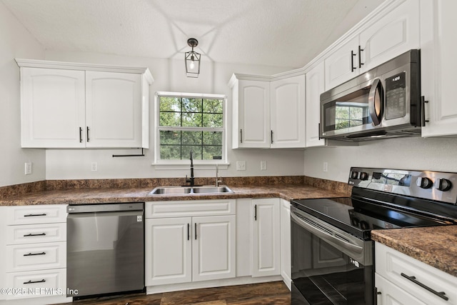 kitchen with sink, a textured ceiling, white cabinets, and appliances with stainless steel finishes