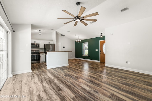 unfurnished living room featuring lofted ceiling, ceiling fan with notable chandelier, and dark hardwood / wood-style floors