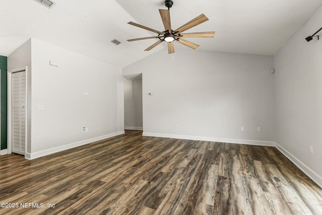 unfurnished room with ceiling fan, dark hardwood / wood-style flooring, vaulted ceiling, and a textured ceiling