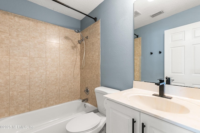 full bathroom with vanity, toilet, tiled shower / bath combo, and a textured ceiling